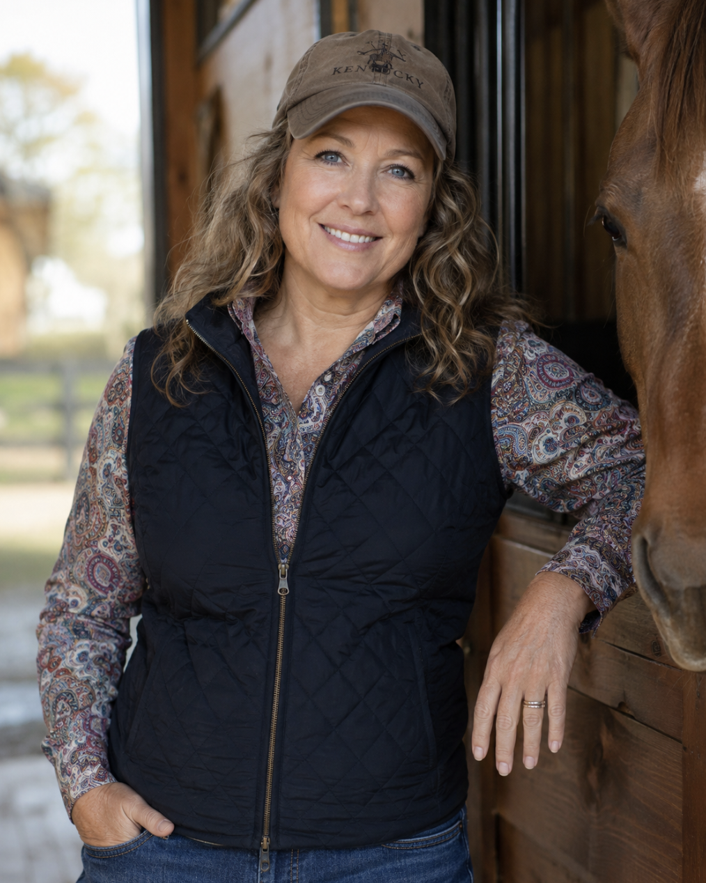 Layona Varell in a barn doorway beside her chestnut horse
